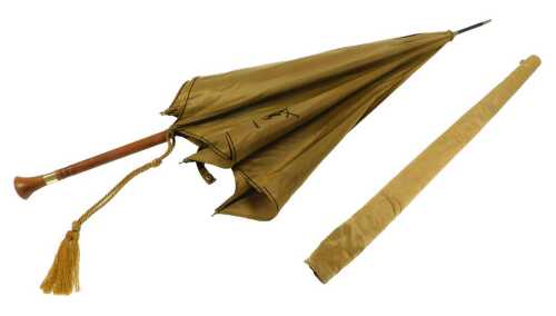 An Yves St Laurent gold fabric umbrella, with a turned wooden handle, with a slip cover, 90cm high.