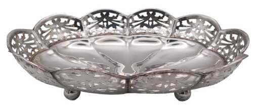 A George V silver oval dish, of fluted form, with a pierced gallery decorated with scrolling...