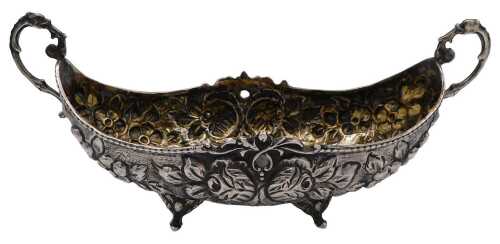 An early 20thC Continental boat shaped dish, with foliate scroll handles, embossed with flowers,...