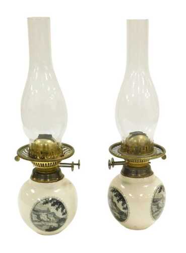 A pair of early 20thC duplex brass and pottery oil lamps, printed in black with roundels...