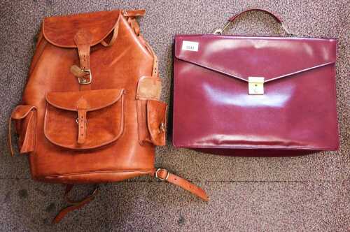 A tan leather ruck sack, together with a maroon red leather file bag. (2)