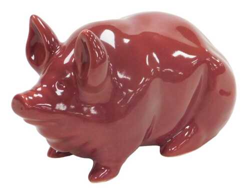 An early 20thC Wemyss ware red glazed pig, impressed Wemyss ware and R.H & S, 19.5cm wide.