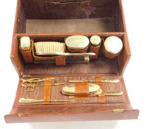 An early 20thC Cartier tan leather vanity case, gilt monogram stamped, with a brown watered silk... - 2