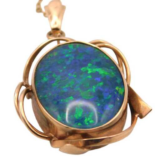 An opal doublet pendant, within an oval abstract metal frame, yellow metal, stamped 9ct, 4.1g...