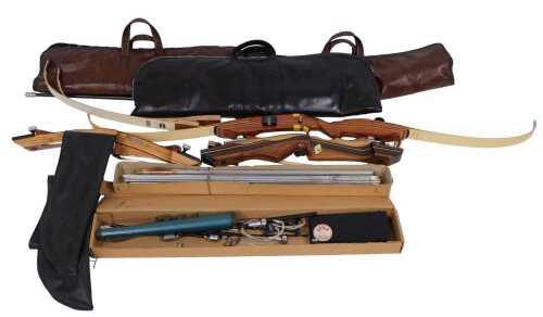 Four wooden crossbows, each with holdalls, and two boxes of arrows. (6)