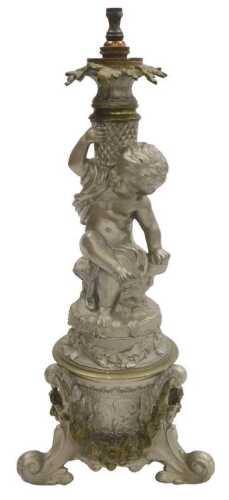 A late 19thC Continental brass table lamp, largely silver painted, decorated with a putto,...