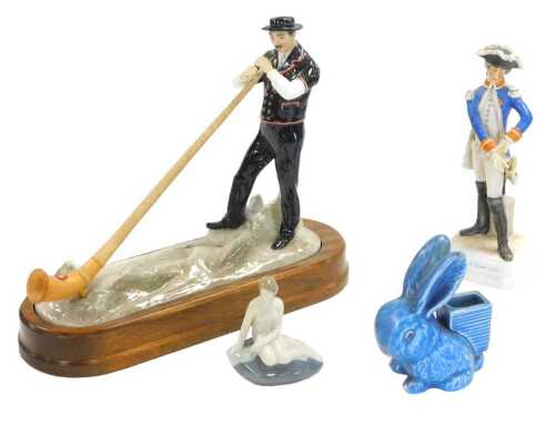 A Royal Worcester porcelain figure of a Swiss man playing an alphorn, on a wooden stand, printed...