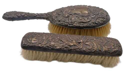 An Edward VII silver backed hairbrush, embossed with masks, flowers and foliate scrolls, vacant...