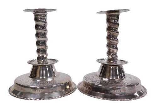 A pair of George V silver candlesticks, with stipple engraving, and a spiral twist column,...
