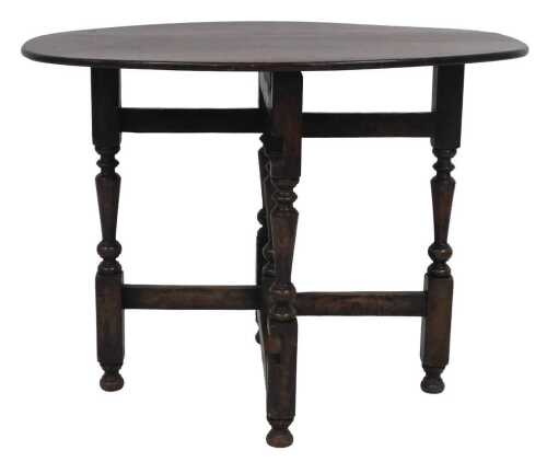 An oak oval folding table, the hinged top, with turned supports, the top 62cm high, 81cm x 58cm.