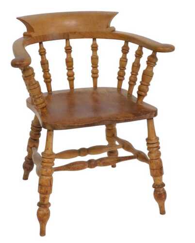 A 19thC ash and elm captain's chair, with spindle turned supports, solid seat, on turned legs...