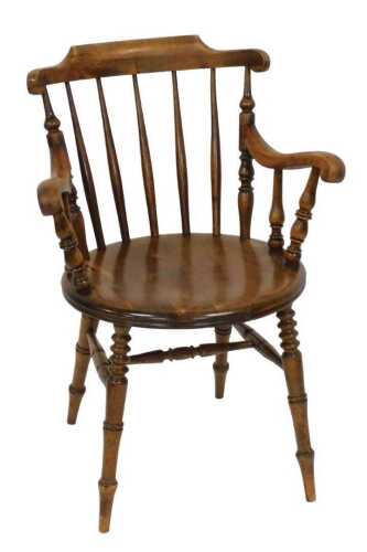A Swedish Ibex brand stickback beech kitchen armchair, with a solid seat, on turned legs with a...