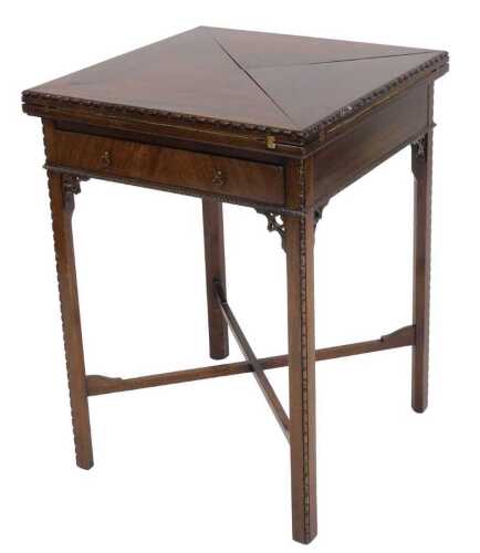An Edwardian mahogany envelope card table, the square top hinged to reveal a baize lined...