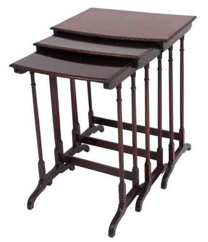 A nest of three Edwardian mahogany D shaped occasional tables, the largest with a carved border,...