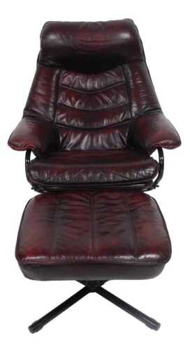 An oxblood leather adjustable armchair, with black tubular metal frame and X shaped base, with...
