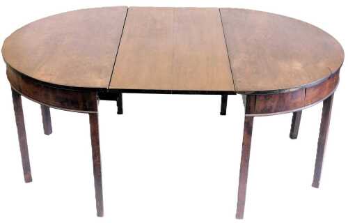 A George III mahogany D-end dining table, with a central drop flap section, raised on tapering...