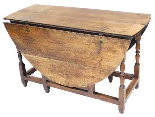 An 18thC oak oval drop leaf table, with turned supports, 72.5cm high, 120cm wide. (AF)