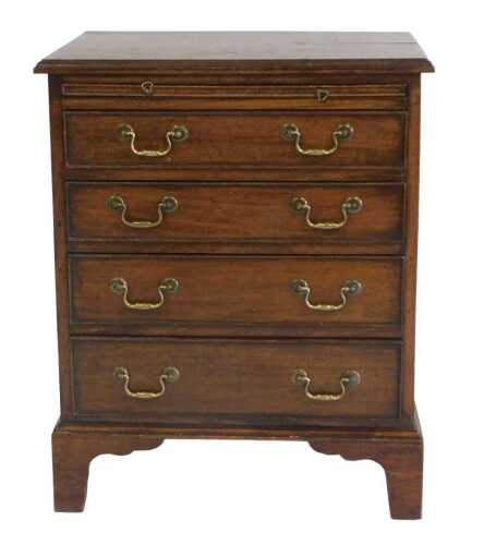 A narrow mahogany chest of drawers, the rectangular top with a moulded edge, above a brushing...