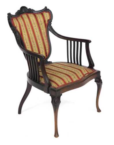 A Victorian mahogany armchair, with a shell capped shield shaped back, and serpentine seat, with...