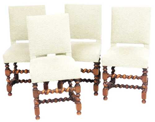A set of four beech dining chairs, each upholstered in pale green patterned fabric, with piped...