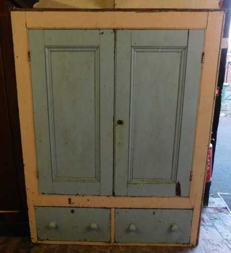 A 19thC painted pine cupboard, with two panelled doors above two drawers, previously part of a...