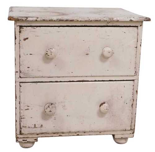 A Victorian cream painted chest of drawers, the distressed top above two drawers, each with...