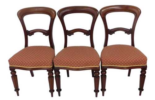 A set of three Victorian mahogany balloon back chairs, each with a red and gold patterned fabric...