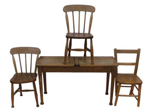 An early 20thC oak double child's chair, with a hinged book compartment, on turned legs, 91cm...