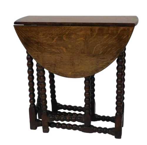 An oak drop leaf table, the oval top on bobbin turned gate supports, in part constructed from...