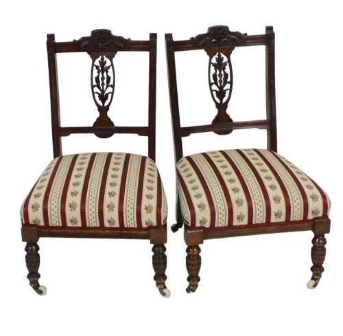 A pair of Edwardian walnut nursing chairs, each with a pierced splat and padded seat,...