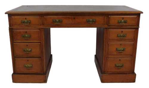 An Edwardian oak pedestal desk, with three frieze drawers and a green leather inset, above an...