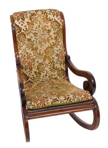 A 19thC mahogany rocking chair, with a padded back and loose cushion, scroll carved arm, on...