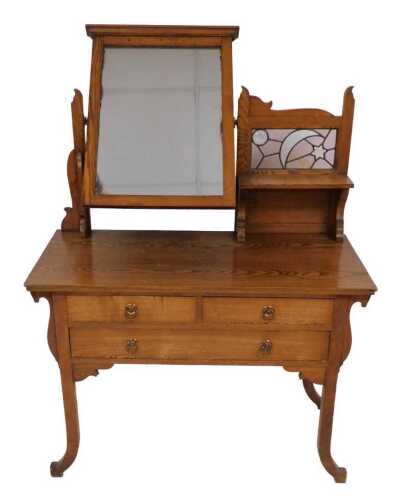 A late 19th/early 20thC oak dressing table, in the manner of Liberty, with a rectangular mirror,...