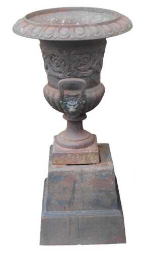 A cast metal campana style garden urn, with lappet border and twin handles, raised on a square...