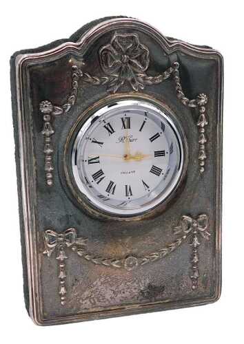 An Elizabeth II silver strut bedside clock, circular white dial bearing Roman numerals, centre...