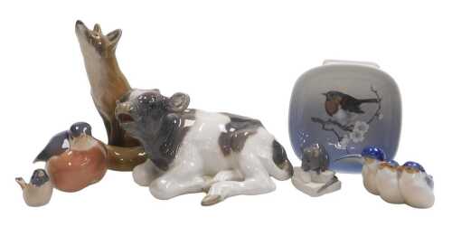A Royal Copenhagen porcelain figure of a seated calf, 17cm wide, a figure of a seated fox, 15cm...