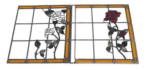 Two clear and stained glass panels, each decorated with roses, within amber and leaded borders,...