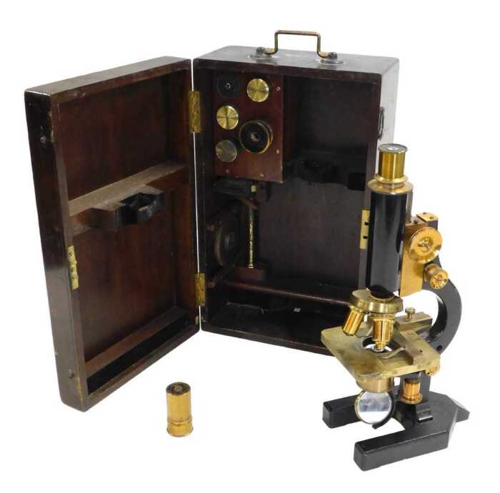 A late 19thC brass and black Japanned monocular compound microscope, with additional lenses, cased.