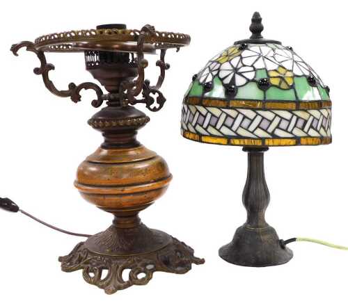 A small Tiffany style lamp, decorated with flower heads in white and yellow on a green ground,...