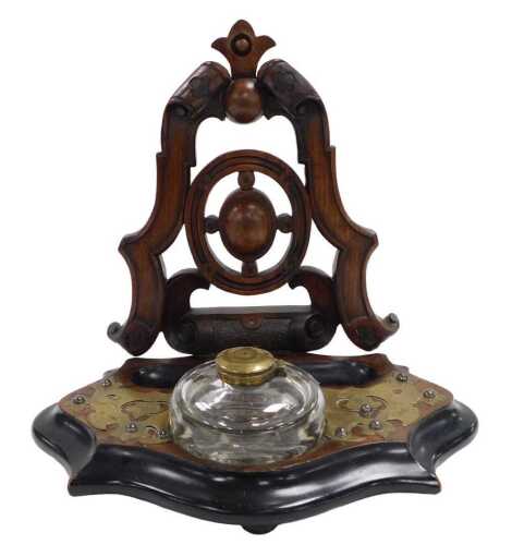 A Victorian walnut ebonised and brass inkstand, with pierced back, the shaped base engraved with...