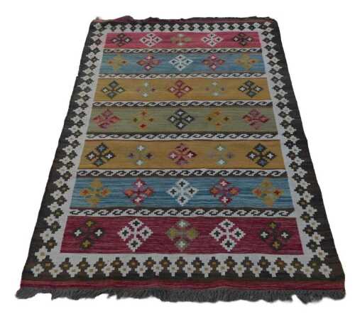 An Afghan Kelim rug, polychrome decorated with seven bands, each containing five stylised floral...