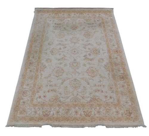 An Indian carpet, with a design of pale blue and red flowers, on a cream ground, one wide and...