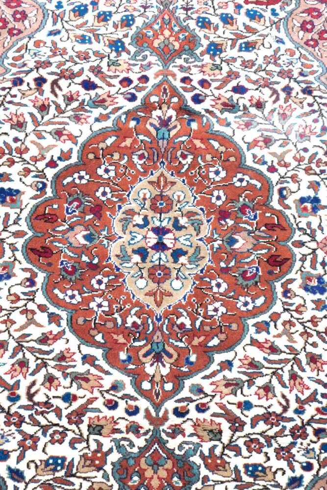 An Indian rug, with a central medallion in brown, on a cream ground ...