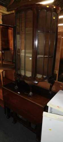 A mahogany drop leaf table, together with a mahogany bow fronted display cabinet, raised on ball...