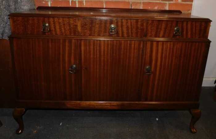 A mahogany sideboard, with three drawers above three cupboard doors.