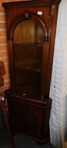 A walnut standing corner cabinet, the open top with two shelves above a door, 65cm wide.