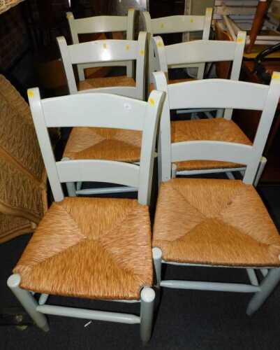 A set of six dining chairs, each painted in duck egg blue, with a rush seat.
