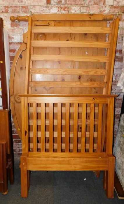 A pine single bed, comprising headboard, footboard and base, and a pine kingsize bedhead.