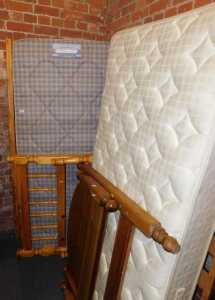 A pine single bed, comprising headboard, footboard, base and mattress, and another.