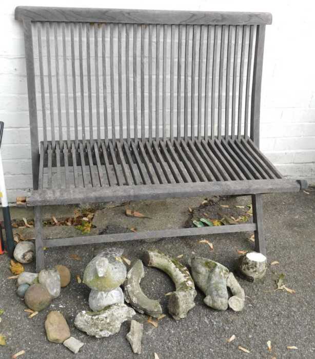 A teak folding garden bench, with slatted seat and back, together with various garden ornaments...